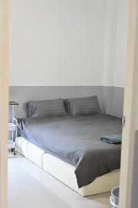 a bed in a room with a white wall at บ้านอิงฟ้าแม่ฮ่องสอน in Ban Mai Ngae
