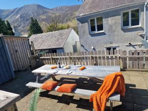 a wooden picnic table with orange pillows on a patio at Annest in Bangor