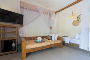 a room with a bed and a tv and a room with at Gili Air Bungalows in Gili Islands