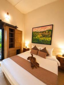 a bedroom with a large bed with a teddy bear on it at Art Hill Villas in Kao Kuil