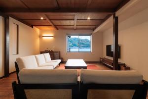 a living room with two couches and a tv at 伊根の舟屋 樹 Funaya Inn Tatsuki , Ine in Kameshima