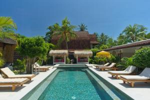 a pool at a villa with lounge chairs and a resort at Gili Air Bungalows in Gili Islands