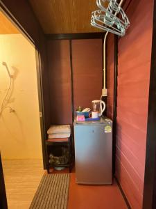 a small refrigerator in a room with a red wall at Lamai Home 2 in Ko Yao Noi
