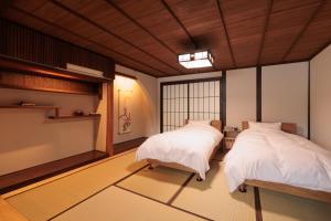 a room with two beds and a window at 伊根の舟屋 樹 Funaya Inn Tatsuki , Ine in Kameshima