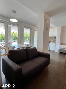 a living room with a black couch and a table at Casa Maly in Portorož