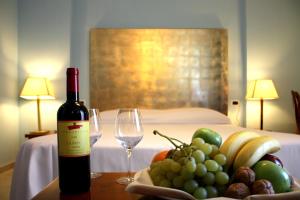 a bottle of wine on a table with a bowl of fruit at Hotel Terme Marine Leopoldo II TERME & SPA in Marina di Grosseto