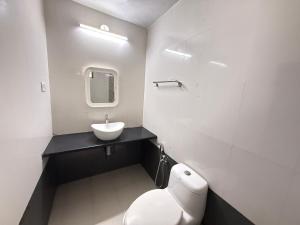 a bathroom with a white toilet and a sink at RnB Beach Resort in Anjuna +12 photos