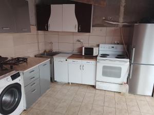 a kitchen with a stove and a sink and a refrigerator at Guest house Mirijevski Konak in Belgrade