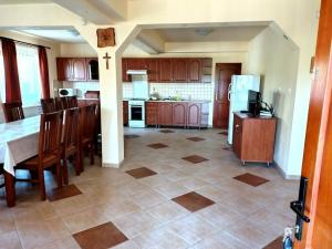 a kitchen with a table and chairs and a refrigerator at Akácpatak Vendégház in Lupeni +11 photos