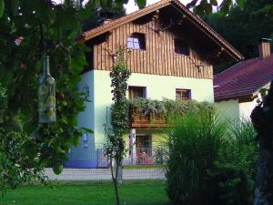 a house with a wooden roof and green grass at Ruhige Oase mit Pool & Garten Ferienwohnung Niggl in Untergriesbach
