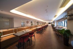 a restaurant with tables and chairs in a room at Citadines Luyang Hefei in Hefei