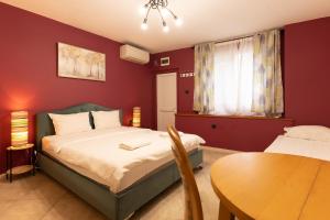 a small bedroom with a bed and a table at Aleko Apartments City Center in Veliko Tŭrnovo