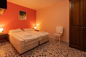 a bedroom with a bed with an orange wall at Aleko Apartments City Center in Veliko Tŭrnovo