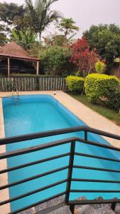 a blue swimming pool next to a fence at APARTMENT 01 Meadowbrook Home Stade in Kasaayi