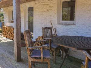 a table and chairs on the porch of a house at Gun Powder Cottage in Tighnabruaich
