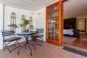 - une chambre avec une table, deux chaises et une porte dans l'établissement The Garden View Suite, à Franschhoek