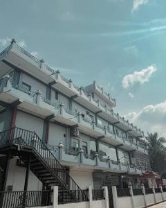 a large white building with stairs on the side of it at Best Inn in Jaffna
