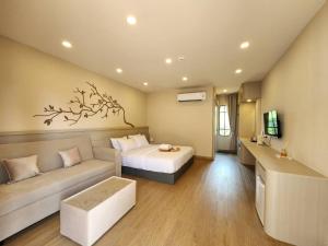 a hotel room with a bed and a couch at Phusira ภูศิรา กาญจนบุรี in Ban Tha Kilen (1)