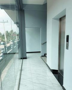 an empty hallway of an office building with a glass door at Best Inn in Jaffna