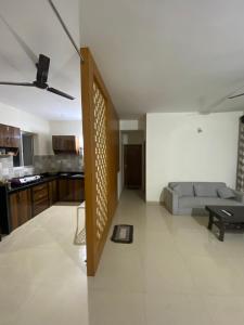 a living room with a couch and a kitchen at Spacious 2BHK Mountain View - Near Palolem Beach in Canacona