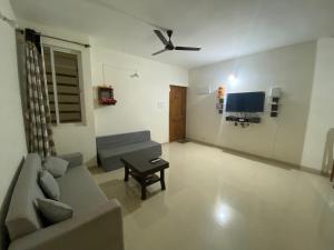 a living room with a couch and a tv at Spacious 2BHK Mountain View - Near Palolem Beach in Canacona