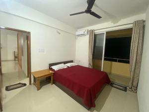 a bedroom with a red bed and a window at Spacious 2BHK Mountain View - Near Palolem Beach in Canacona