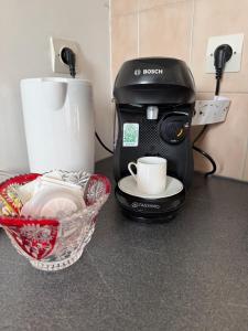 a coffee maker sitting on a counter next to a bowl at Bienvenue au Nid Rosé in Montereau-Fault-Yonne