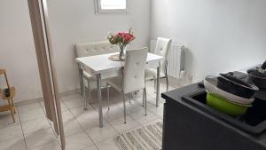 a kitchen with a table and a white table and chairs at Bienvenue au Nid Rosé in Montereau-Fault-Yonne +6 photos