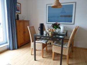 a dining room table with chairs and a black table at Leuchtturmblick Villa Silva mit Fahrradkellerstellfläche in Kühlungsborn