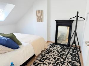 a bedroom with a bed and a mirror on the wall at TRIPLEX 2 chambres Cosy à MONS in Mons
