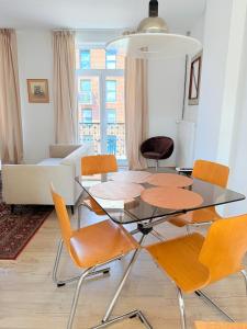 a dining room with a glass table and chairs at TRIPLEX 2 chambres Cosy à MONS in Mons