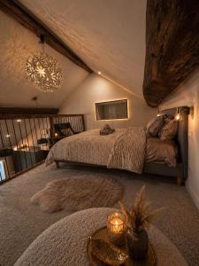 a bedroom with a large bed and a chandelier at Love Room balnéo double & sauna Privés - Nuit d'exception in Briord