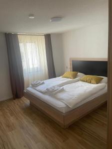 a large bed in a bedroom with a window at Die Perle an der Wutach in Lauchringen
