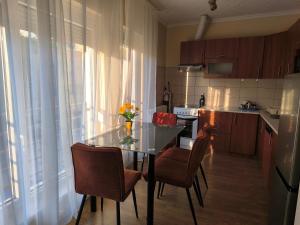 a kitchen with a table and chairs and a kitchen with a window at FAVORIT CENTRUM Apartman in Kaposvár +8 photos