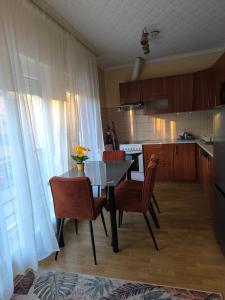 a kitchen with a table and chairs and a table and a kitchen with a kitchen at FAVORIT CENTRUM Apartman in Kaposvár