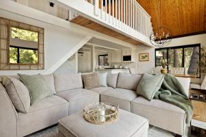 a living room with a large couch and a staircase at The Arrowhead Pearl in Lake Arrowhead