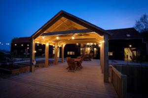 a pavilion with a wooden deck at night at Creeksea Place Barns in Burnham on Crouch