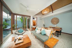 a living room with a couch and a table at Sanora Villa Sanur by Ini Vie Hospitality in Sanur
