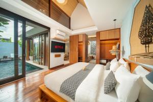 a bedroom with a bed and a swimming pool at Sanora Villa Sanur by Ini Vie Hospitality in Sanur +49 photos