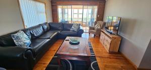 a living room with a leather couch and a coffee table at Mountain View in Klein-Brakrivier