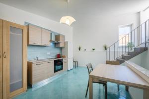a kitchen and dining room with a table and a staircase at La casa del Pescatore in Procida