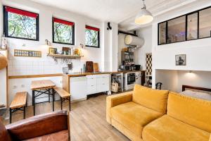 a living room with a couch and a kitchen at Atelier Bleu Charmant petit Loft in Clichy