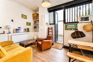 a living room with a couch and a table at Atelier Bleu Charmant petit Loft in Clichy