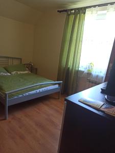 a bedroom with a bed and a window and a desk at Przylesie in Uniejow