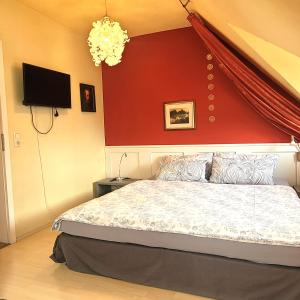 a bedroom with a bed with a red wall at Logis Am Park in Dessau