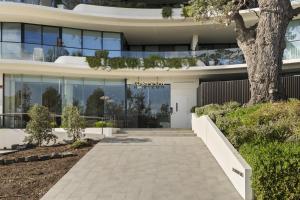a building with a tree in front of it at Azure Horizon - Bay Views & Rooftop Spa in Frankston