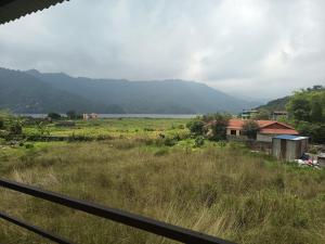 a view of a field with mountains in the background at hotel lakema in Pokhara