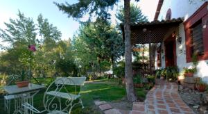 a patio with a table and a chair in a yard at Casa Rural Finca Umbría in Plasencia