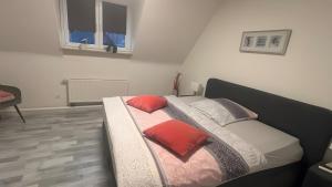 a bed with two pillows on it in a room at Ferienwohnung auf dem Traumpfad in Ettringen
