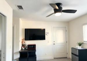 a living room with a ceiling fan and a flat screen tv at Downtown Private Master Suite in Sacramento +10 photos
